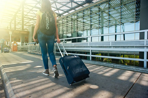 female arriving at airport with luggage