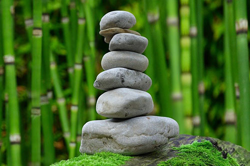 Zen garden stone stacked tower in front of bamboo.